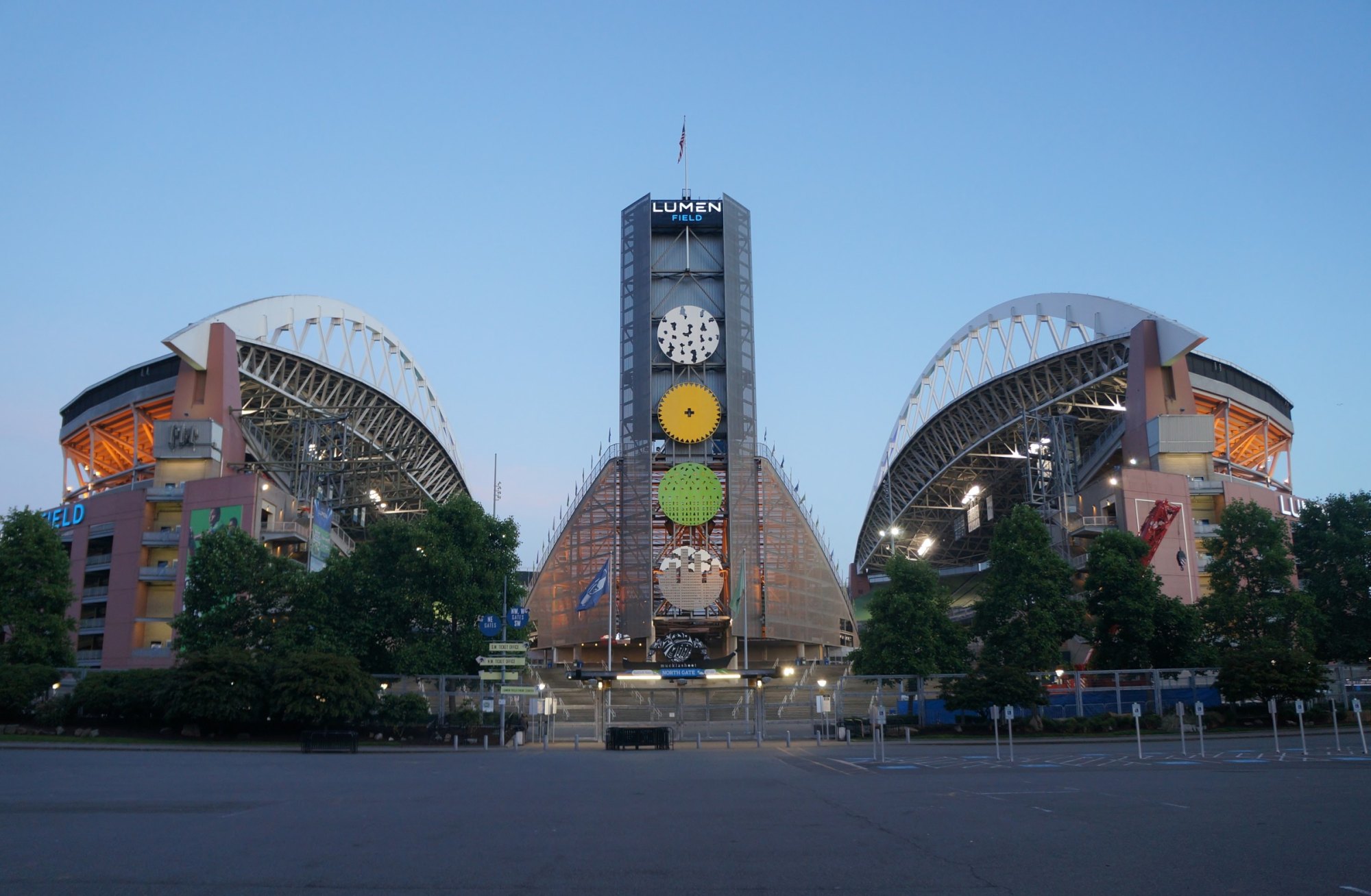 Lumen Field stadium north entrance with lit tower and arched roof trusses at dusk